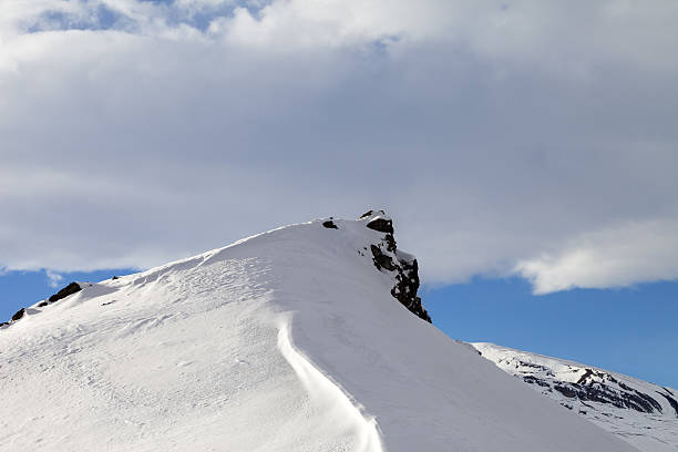 Top of mountains with snow cornice after snowfall