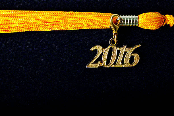 istock yellow tassel and 2016 pendant on black graduation hat 515078434