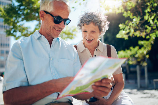 istock Elderly couple sitting on a bench and using city map 515078990