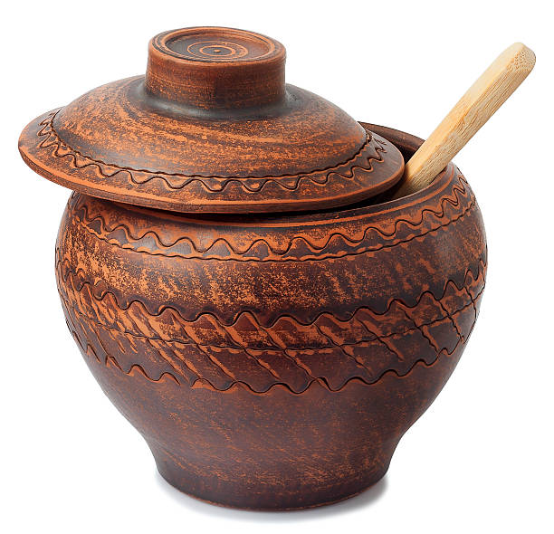 istock Clay pot and wooden spoon on white background 515081900