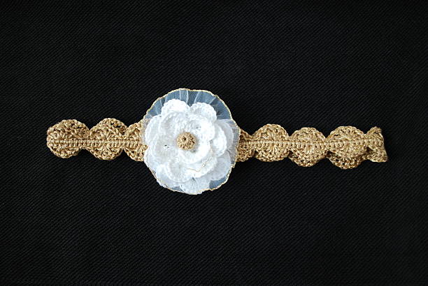 istock Crocheted gold headband with white flower. 515083212