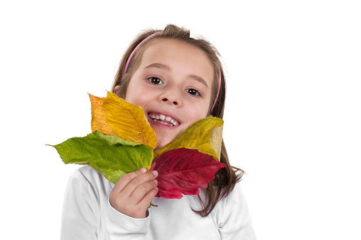 Cute girl holding autumn leafs isolated on white