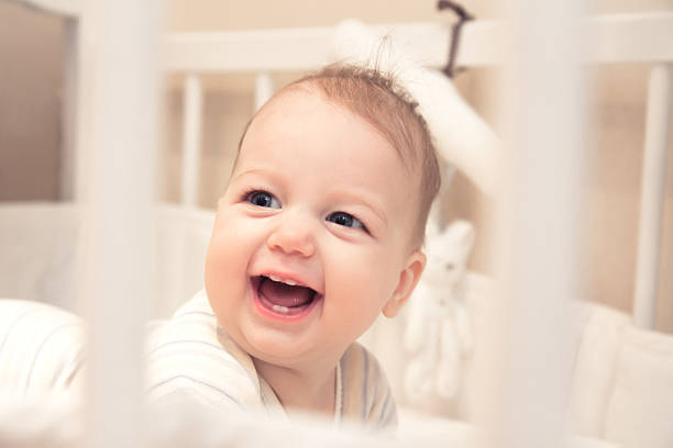 istock Funny laughing baby girl in cot 515146346