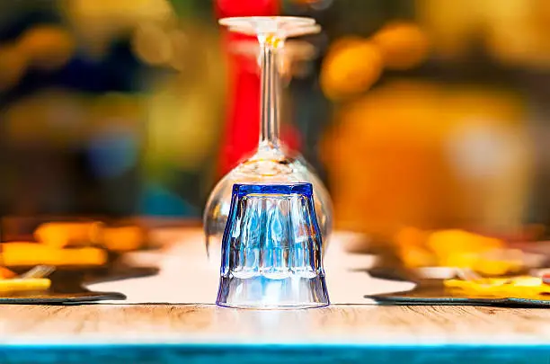Colorful upside down glasses on a restaurant table for dinner