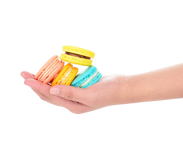 istock hand holding colorful macarons on white background 515150616