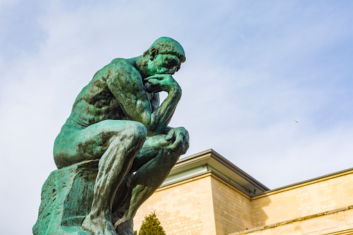 Paris, France - December 5, 2015: August Rodin's famous sculpture The Thinker in the grounds of the Musee Rodin, Paris