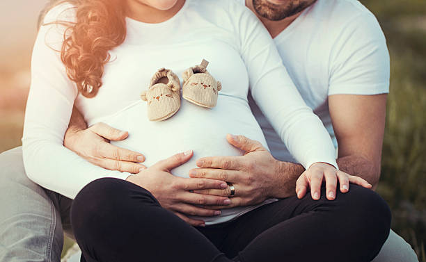 jeune couple attend un bébé - abdomen adult affectionate baby photos et images de collection