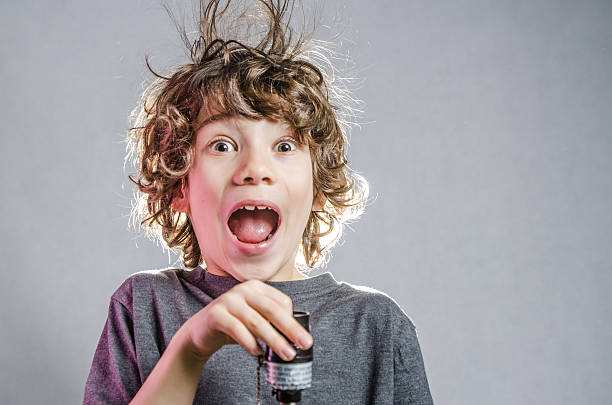 Little boy with hair electrified with finger in light socket