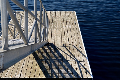 Weathered wood dock with metal ramp for docking boats.