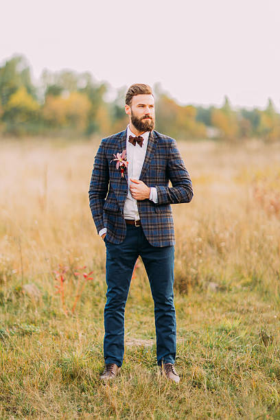 istock Handsome hipster groom with beard posing on the autumn field 515154122