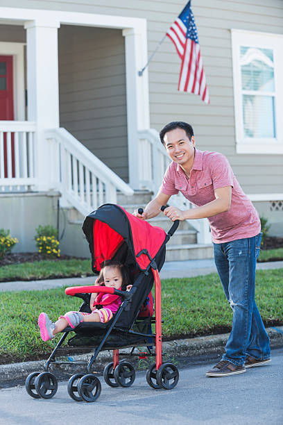 istock Asian father pushing his daughter in stroller 515158128