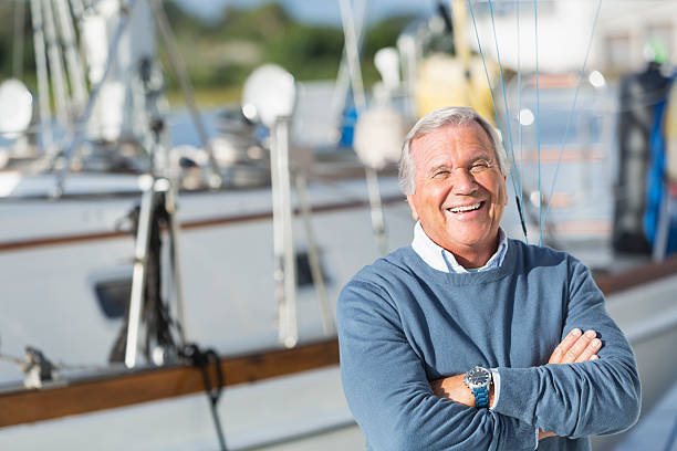 Happy senior man smiling on boat at harbor