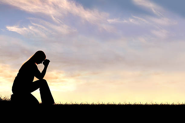 istock Woman Sitting Down in Prayer Silhouette 515169585