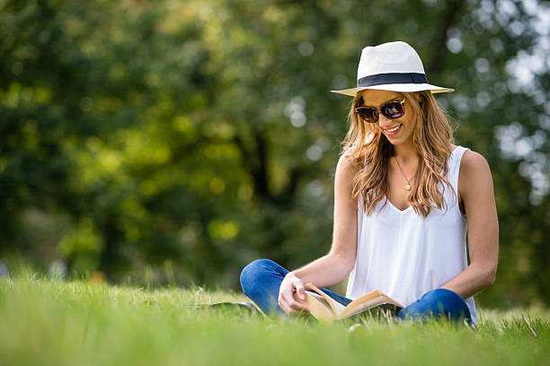 Summer woman reading a book at the park