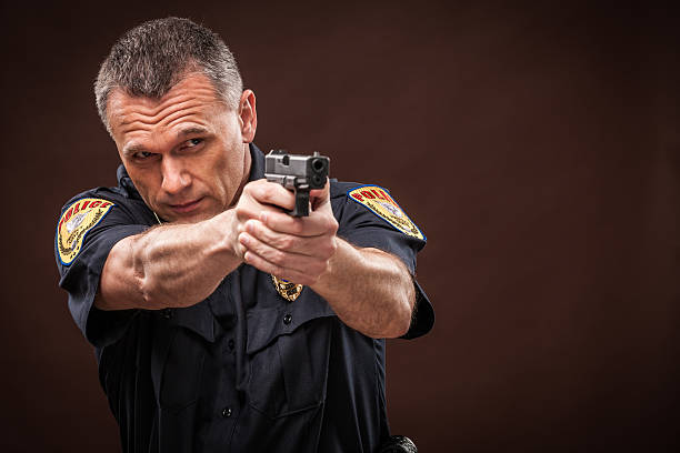 Full size profile side photo of serious policewoman look copyspace aiming weapon protect isolated on yellow color background