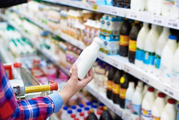 mujer de compras en la tienda de productos lácteos - lácteos supermercado fotografías e imágenes de stock