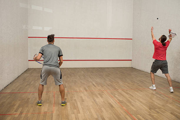 vista traseira do homens jogando abóbora por um tribunal. - squash racketball sport exercising imagens e fotografias de stock