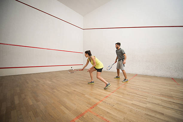 casal atlético jogar raquetebol em um tribunal. - racket ball indoors competition imagens e fotografias de stock