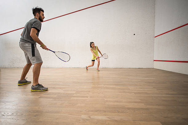 athlétique jeune couple jouant au courge dans le cour. - racketball racket ball court photos et images de collection