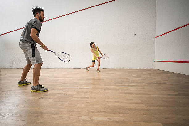istock Young athletic couple playing squash on a court. 515193024