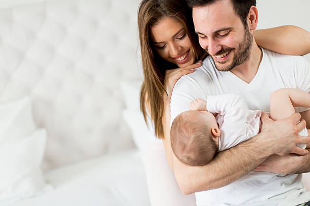 famiglia felice con un neonato - baby two parent family newborn family foto e immagini stock