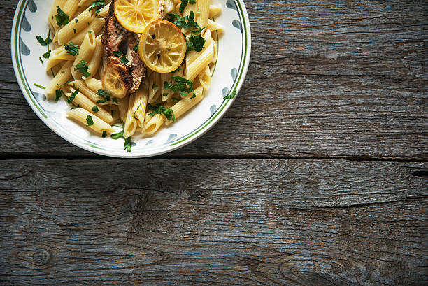 istock Salmon fillet on tagliatelle, herbs, lemon, top view, penne pasta 515194238