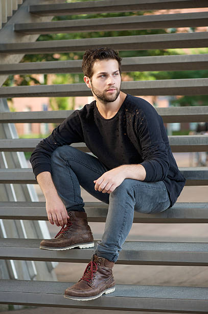 istock Cool guy in black clothing sitting on steps 515197083