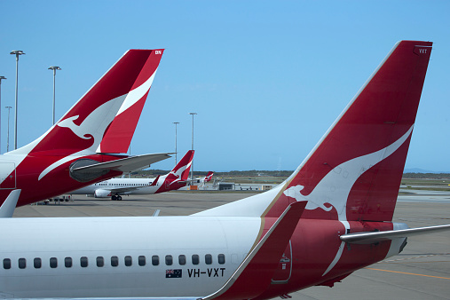 Brisbane, Australia - September 25, 2014: looking through window at Brisbane airport, tails of Qantas planes parked on tarmac with no people.