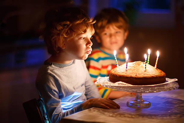 小さなお子様用の少年は兄弟てキャンドルのバースデーケーキ - birthday family party cake ストックフォトと画像