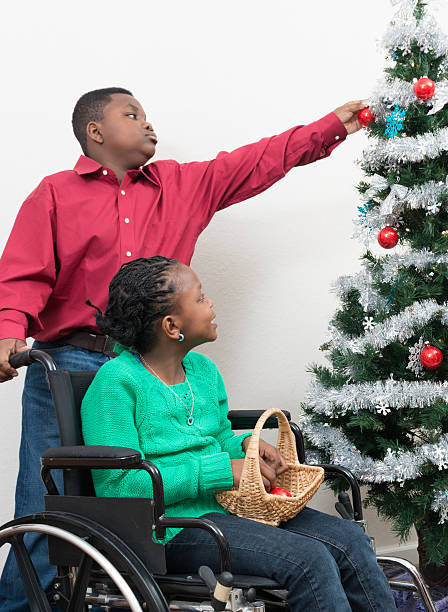 istock Brother assisting disabled sister decorate Christmas tree 515200139
