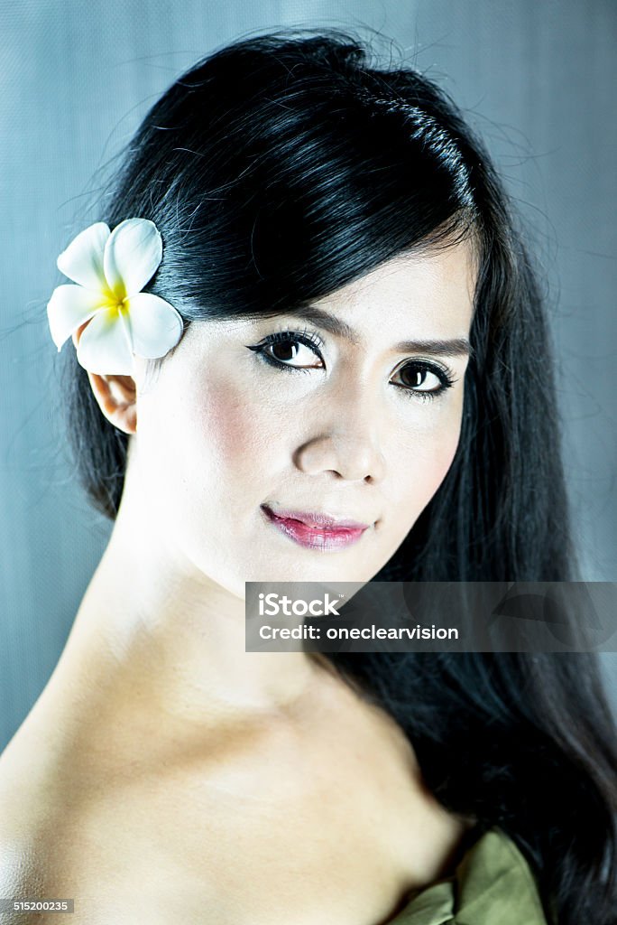 Beautiful Asian Woman Beautiful Asian woman with a frangipani flower in her hair. This image was made with a Nikon D800 full frame camera and Nikon 105mm prime lens. 30-39 Years Stock Photo