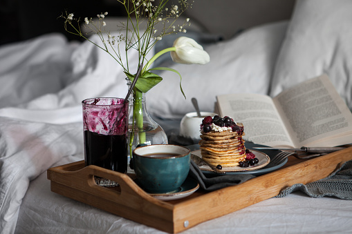 Served breakfast in bed. Pancakes with berries and coffee