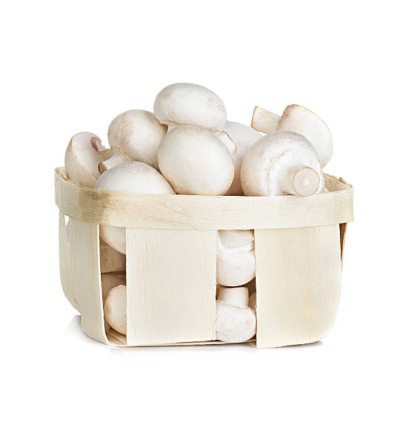 istock Champignon mushrooms in a wooden container, isolated on white background 515202877