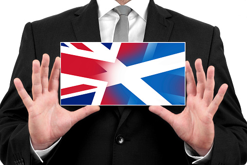 Businessman holding business card with Scotland and United Kingdom Flag