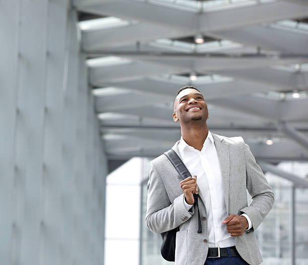 счастливый молодой человек с сумки в аэропорт - men african descent looking up smart casual стоковые фото и изображения