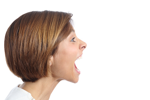 Profile of an angry young woman shouting isolated on a white background