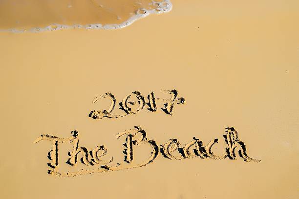 istock 2017 written in sand, on tropical beach 515223504
