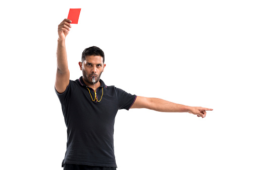 Portrait of referee whistling and showing red card