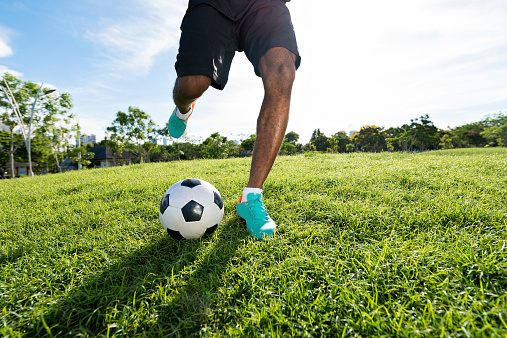 Legs of soccer player kicking the ball