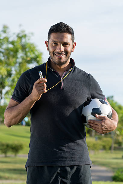 Cheerful soccer coach Portrait of cheerful soccer coach holding a ball whistling stock pictures, royalty-free photos & images