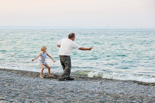 Grampa and Granddaughter skipping rocks
