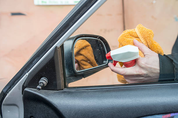 istock Hands Cleaning Side View Mirror with Spray Bottle, Close-up 515226278