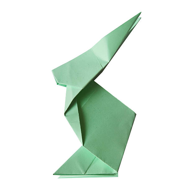 A close-up of a hand holding an orange paper airplane against a blurred background, symbolizing creativity, childlike wonder, and aspirations.