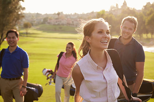 gruppe von golfer zu fuß auf den fairway golf-taschen tragen - playing golf fotos stock-fotos und bilder