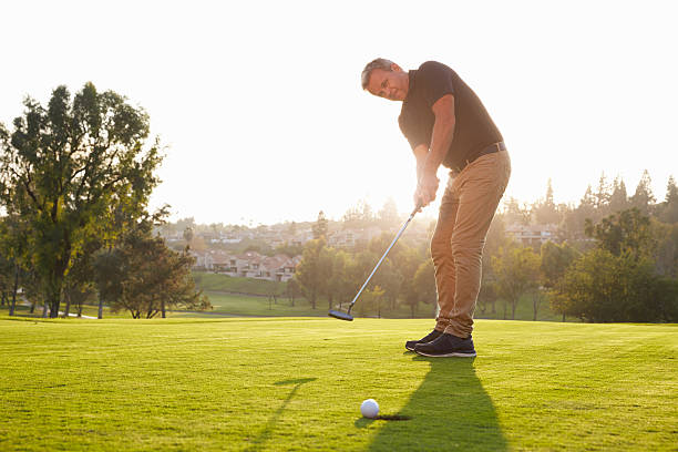 istock Male Golfer Putting Ball Into Hole On Green 515230556
