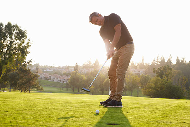istock Male Golfer Putting Ball Into Hole On Green 515230672