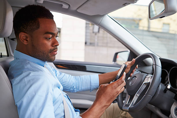 istock Young African American male driver using phone, in car view 515230980