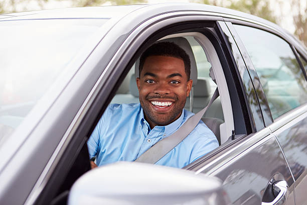 istock African American male driver looking to camera through car window 515231036