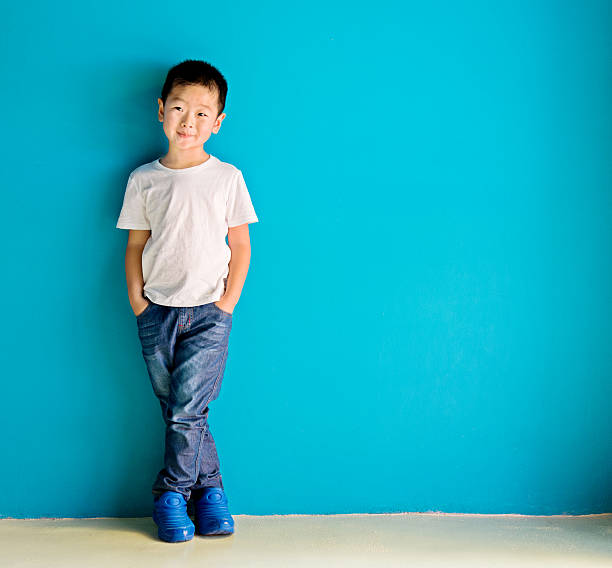 chinês menino contra a parede - child little boys isolated standing - fotografias e filmes do acervo