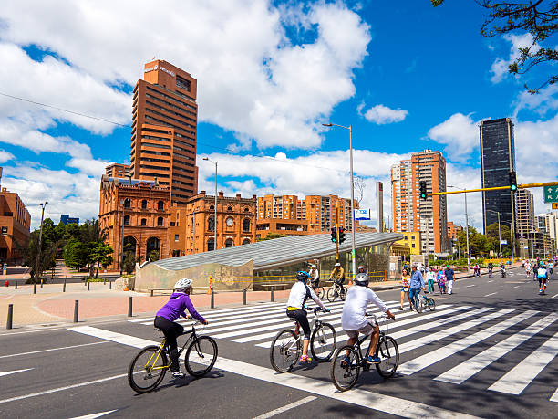 Bogota, Colombia - January 12, 2015: Bikers crossing an intersection during a marathon in Bogota, Colombia. City buildings can be seen in the background.